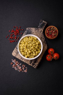 Koyu beton arka planda tuz ve baharatlı buğdaydan lezzetli ditali makarna.