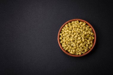 Koyu beton arka planda tuz ve baharatlı buğdaydan lezzetli ditali makarna.