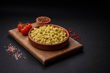 Koyu beton arka planda tuz ve baharatlı buğdaydan lezzetli ditali makarna.