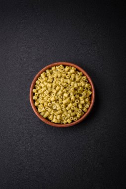 Koyu beton arka planda tuz ve baharatlı buğdaydan lezzetli ditali makarna.