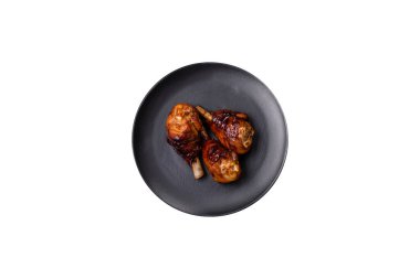 Lezzetli ızgara tavuk bacağı. Baharatlı ve otlu teriyaki soslu. Koyu beton arka planda.