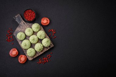 Ham khinkali ya da yeşil hamur köfteleri, koyu beton arka planda tuz, baharat ve otlarla.