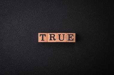 Düz arkaplandaki tahta küplerden yapılmış True yazısını. Tasarımınız için kullanılabilir