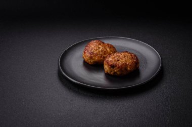 Lezzetli taze kıymalı balık pirzolası. Esmer arka planda baharatlar ve otlarla birlikte.