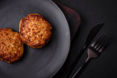 Lezzetli taze kıymalı balık pirzolası. Esmer arka planda baharatlar ve otlarla birlikte.