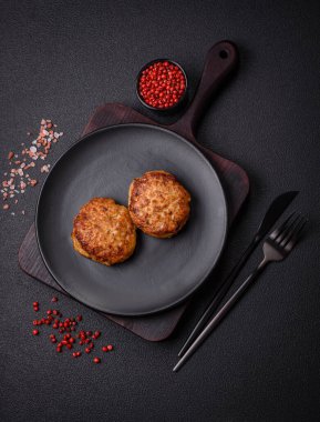 Lezzetli taze kıymalı balık pirzolası. Esmer arka planda baharatlar ve otlarla birlikte.