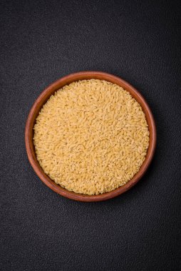 Ham risoni makarnası koyu beton arka planda buğdaydan yapılır. Lezzetli, besleyici bir kahvaltı hazırlıyorum.