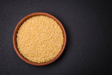 Ham risoni makarnası koyu beton arka planda buğdaydan yapılır. Lezzetli, besleyici bir kahvaltı hazırlıyorum.