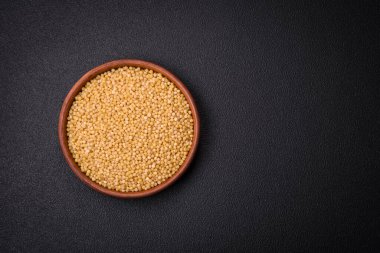 Koyu beton arka planda buğday lapası taneleri. Lezzetli, besleyici bir kahvaltı hazırlıyorum.