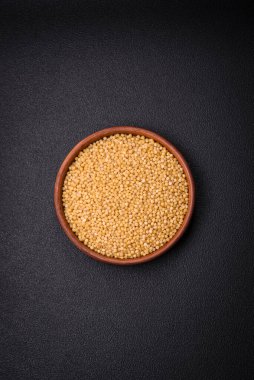 Koyu beton arka planda buğday lapası taneleri. Lezzetli, besleyici bir kahvaltı hazırlıyorum.