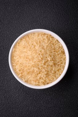 Seramik kasede pişmemiş büyük pirinç taneleri. Lezzetli, besleyici yulaf lapası pişiriyorum.