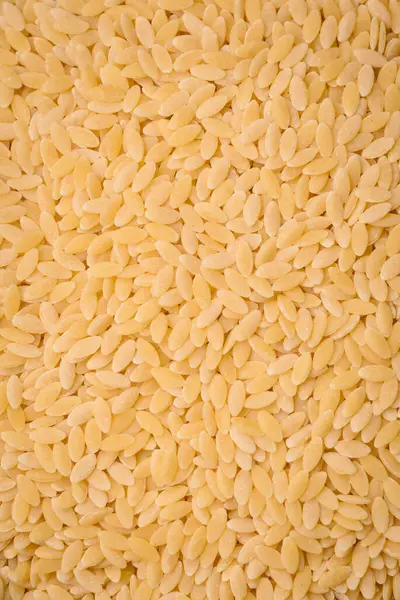 Ham risoni makarnası koyu beton arka planda buğdaydan yapılır. Lezzetli, besleyici bir kahvaltı hazırlıyorum.