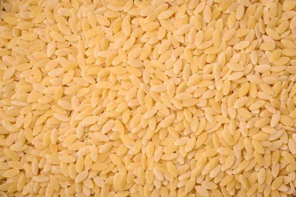 Ham risoni makarnası koyu beton arka planda buğdaydan yapılır. Lezzetli, besleyici bir kahvaltı hazırlıyorum.