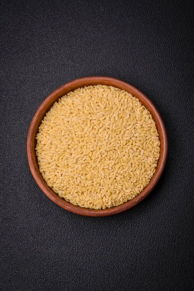 Ham risoni makarnası koyu beton arka planda buğdaydan yapılır. Lezzetli, besleyici bir kahvaltı hazırlıyorum.