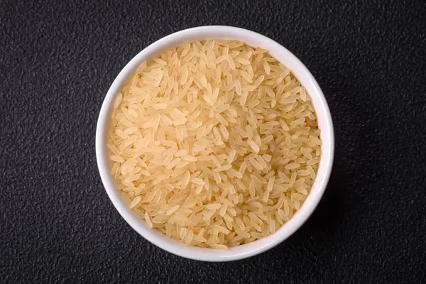 Seramik kasede pişmemiş büyük pirinç taneleri. Lezzetli, besleyici yulaf lapası pişiriyorum.