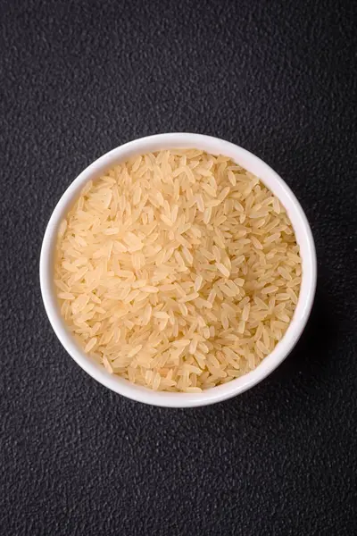 Seramik kasede pişmemiş büyük pirinç taneleri. Lezzetli, besleyici yulaf lapası pişiriyorum.