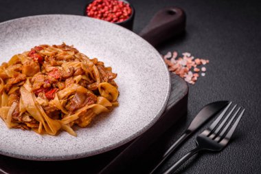 Sebzeli, mantarlı, tuzlu ve baharatlı lezzetli Asya udonu tabağı koyu beton arka planda.