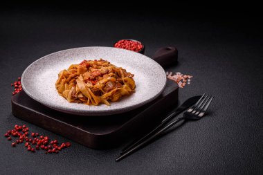 Sebzeli, mantarlı, tuzlu ve baharatlı lezzetli Asya udonu tabağı koyu beton arka planda.