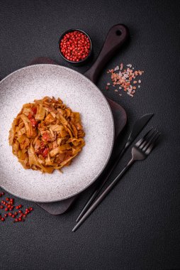 Sebzeli, mantarlı, tuzlu ve baharatlı lezzetli Asya udonu tabağı koyu beton arka planda.