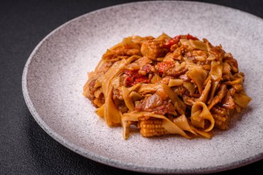 Sebzeli, mantarlı, tuzlu ve baharatlı lezzetli Asya udonu tabağı koyu beton arka planda.