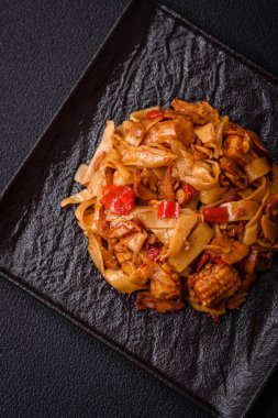 Sebzeli, mantarlı, tuzlu ve baharatlı lezzetli Asya udonu tabağı koyu beton arka planda.