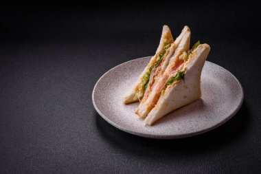 Tost ekmekli, jambonlu, domatesli, peynirli ve soslu lezzetli bir sandviç.