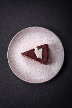 Koyu beton arka planda kremalı ve süngerli lezzetli çikolatalı pasta.