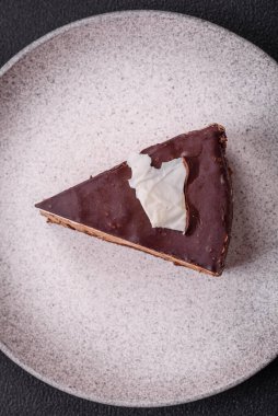 Koyu beton arka planda kremalı ve süngerli lezzetli çikolatalı pasta.