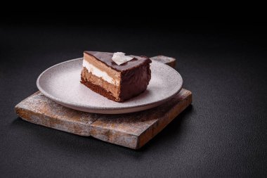 Koyu beton arka planda kremalı ve süngerli lezzetli çikolatalı pasta.