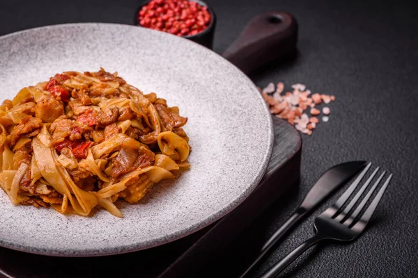 Sebzeli, mantarlı, tuzlu ve baharatlı lezzetli Asya udonu tabağı koyu beton arka planda.