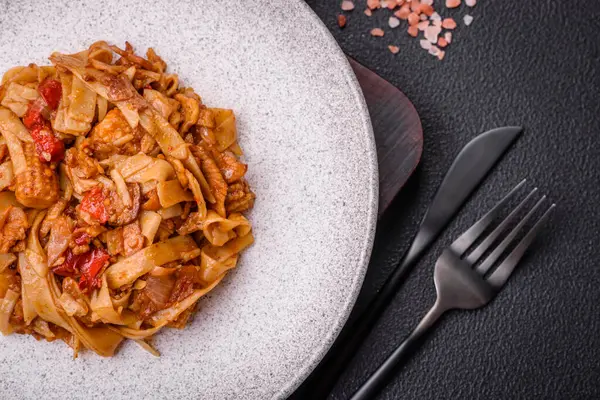Sebzeli, mantarlı, tuzlu ve baharatlı lezzetli Asya udonu tabağı koyu beton arka planda.