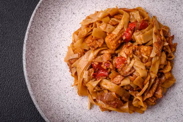 Sebzeli, mantarlı, tuzlu ve baharatlı lezzetli Asya udonu tabağı koyu beton arka planda.