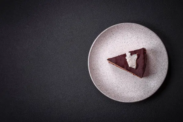 Koyu beton arka planda kremalı ve süngerli lezzetli çikolatalı pasta.