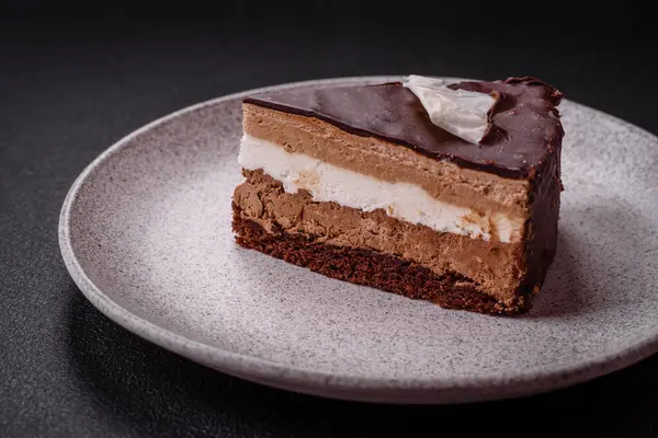 Koyu beton arka planda kremalı ve süngerli lezzetli çikolatalı pasta.
