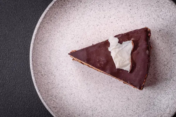 Koyu beton arka planda kremalı ve süngerli lezzetli çikolatalı pasta.