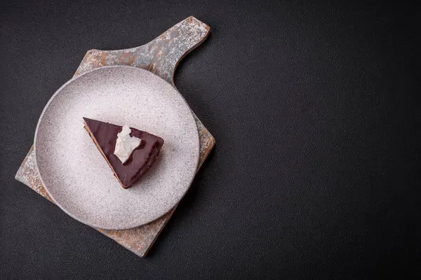 Koyu beton arka planda kremalı ve süngerli lezzetli çikolatalı pasta.