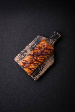 Koyu beton zeminde çikolata ve tuzlu karamel ile lezzetli çıtır çıtır tatlı puf böreği.