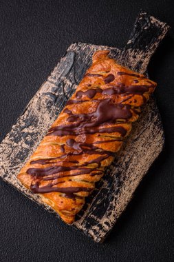 Koyu beton zeminde çikolata ve tuzlu karamel ile lezzetli çıtır çıtır tatlı puf böreği.