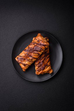 Koyu beton zeminde çikolata ve tuzlu karamel ile lezzetli çıtır çıtır tatlı puf böreği.