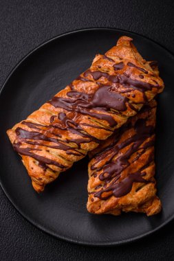 Koyu beton zeminde çikolata ve tuzlu karamel ile lezzetli çıtır çıtır tatlı puf böreği.