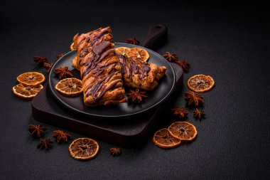 Koyu beton zeminde çikolata ve tuzlu karamel ile lezzetli çıtır çıtır tatlı puf böreği.