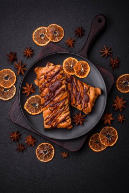 Koyu beton zeminde çikolata ve tuzlu karamel ile lezzetli çıtır çıtır tatlı puf böreği.