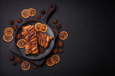 Koyu beton zeminde çikolata ve tuzlu karamel ile lezzetli çıtır çıtır tatlı puf böreği.