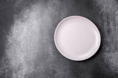 Açık desenli arka planda boş seramik tabak. Mutfak aletleri