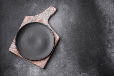 Açık desenli arka planda boş seramik tabak. Mutfak aletleri