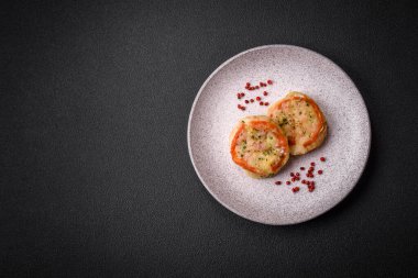 Peynirli, domatesli, tuzlu, baharatlı ve çimento kaplı lezzetli balık filetosu.