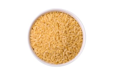 Ham risoni makarnası koyu beton arka planda buğdaydan yapılır. Lezzetli, besleyici bir kahvaltı hazırlıyorum.