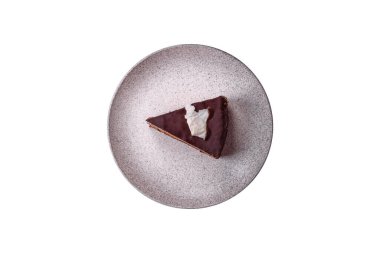 Koyu beton arka planda kremalı ve süngerli lezzetli çikolatalı pasta.