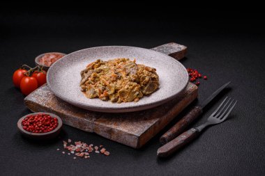 Lezzetli haşlanmış biftek ya da havuç, soğan, ekşi krema ve baharatlı seramik tabakta dilimlenmiş domuz dili.