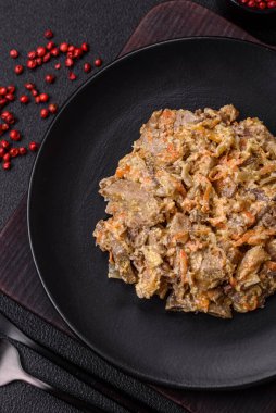 Lezzetli haşlanmış biftek ya da havuç, soğan, ekşi krema ve baharatlı seramik tabakta dilimlenmiş domuz dili.